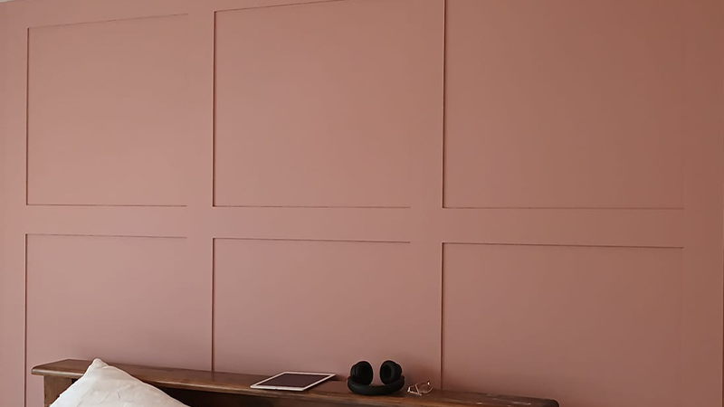 Close up of red panelling behind a headboard in bedroom